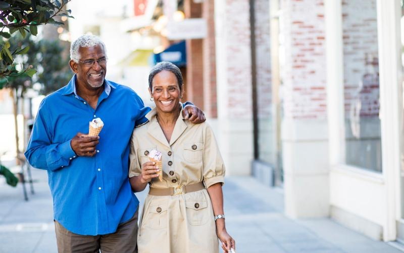 a man and a woman walking with ice cream